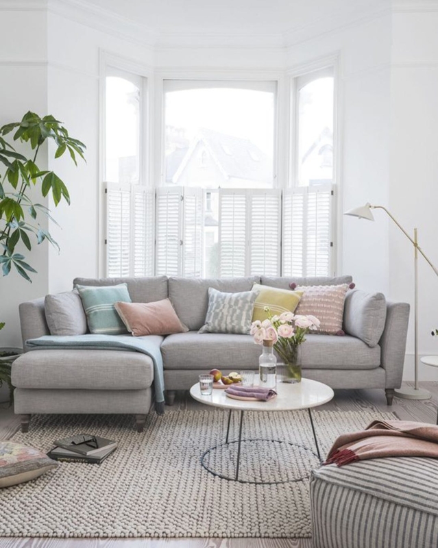 Sectional Sofa with Chunky Knit Rug & Pastel Accent Pillows by Bay Window