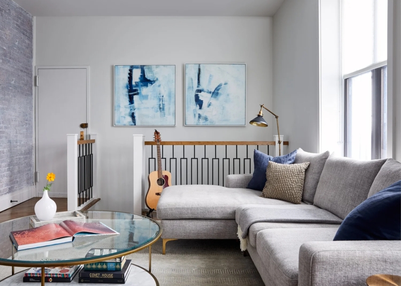 Sectional Sofa with Gold Toned Legs and Whitewashed Brick Accent Wall