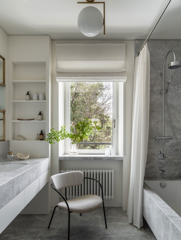 Serene Bathroom with Integrated Wall Niches and Boucle Accent Chair