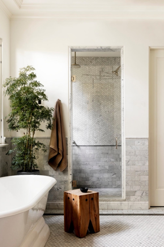 Serene Freestanding Tub with Marble Herringbone Shower and Rustic Stool