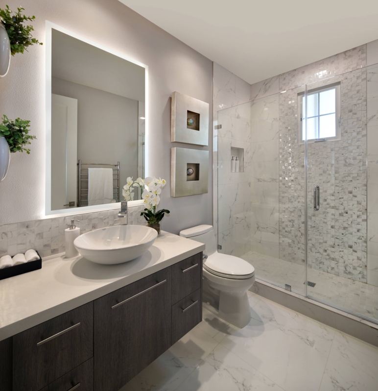 Sleek Bathroom with Backlit Mirror and Dark Wood Vanity