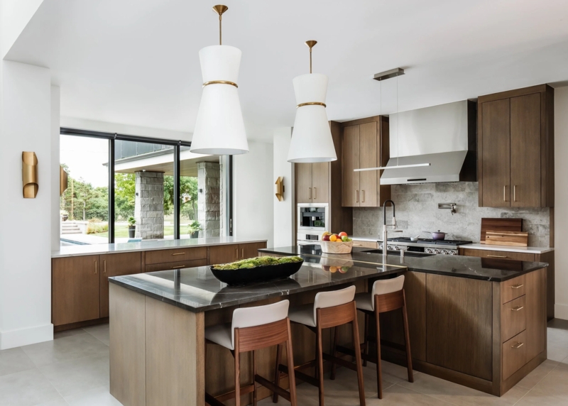 Sleek Kitchen: Black Countertops and White Hourglass Pendants
