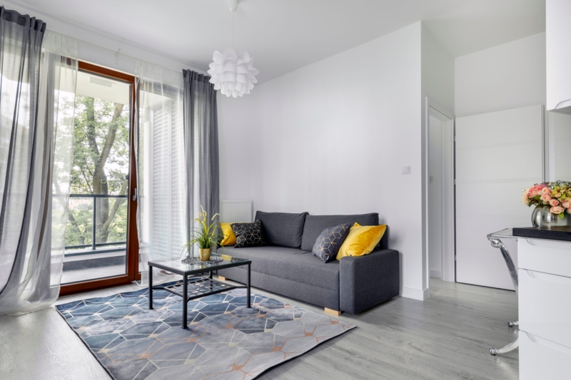 Small Apartment Layout Grey Sofa Geometric Rug Yellow Accents