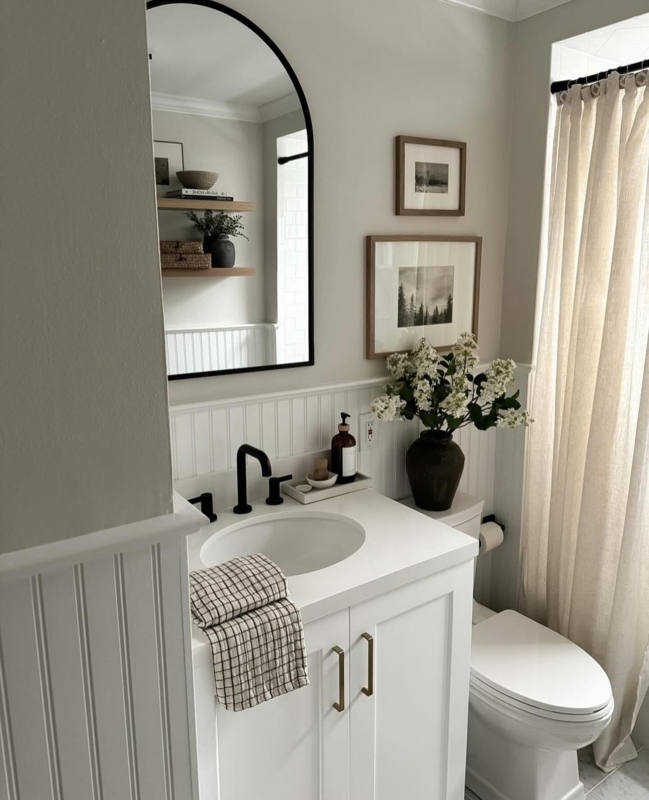 Small Bathroom Beadboard Paneling, Arched Mirror, and Black Fixtures