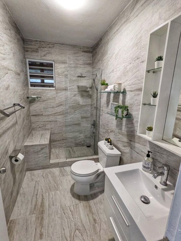 Small Bathroom Design with Floor to Ceiling Stone Tile and Bench