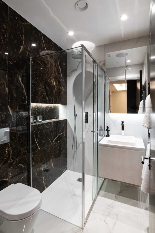 Small Luxury Bathroom with Dark Marble Tiles and Integrated Lighting