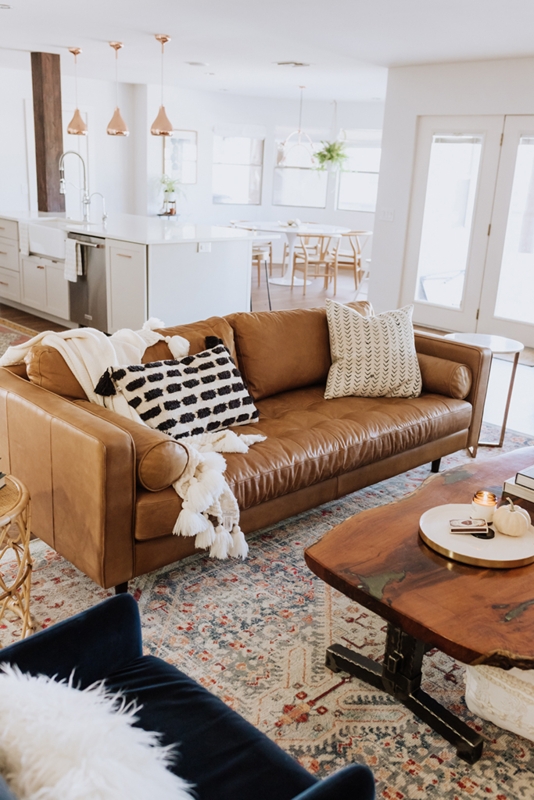 Sofa Cognac Leather Like with Tasseled Knit Throw and Boho Vibes.