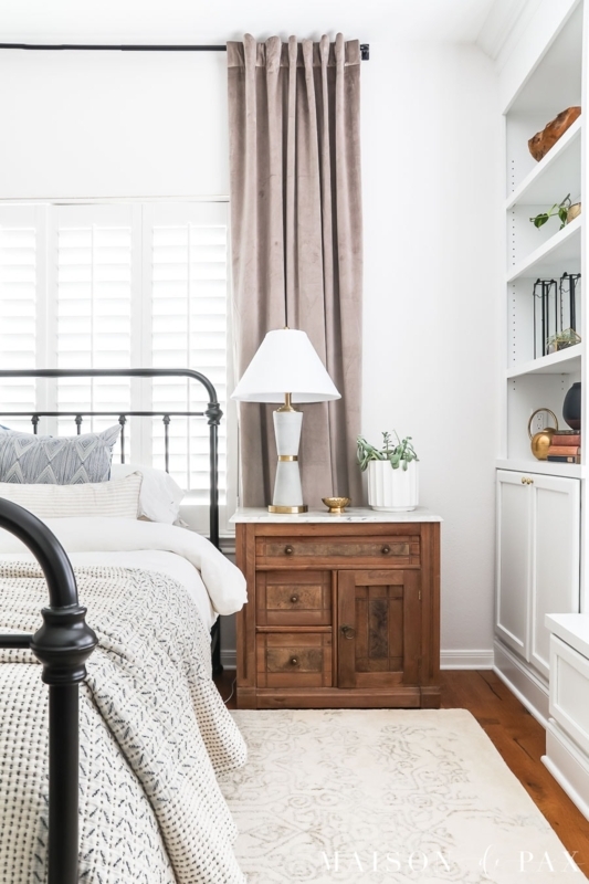 Storage Nightstand with Taupe Velvet Curtains and Black Spindle Bed