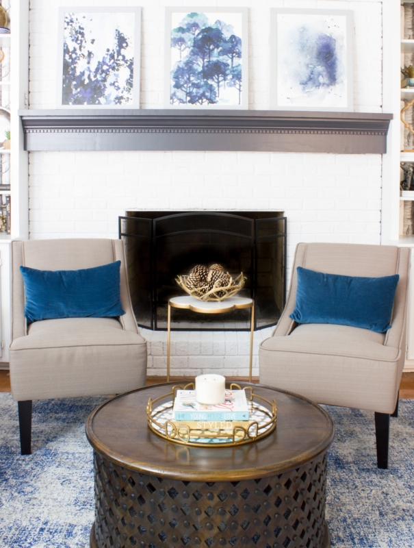 Symmetric Armless Chairs with Navy Accents by a White Brick Fireplace