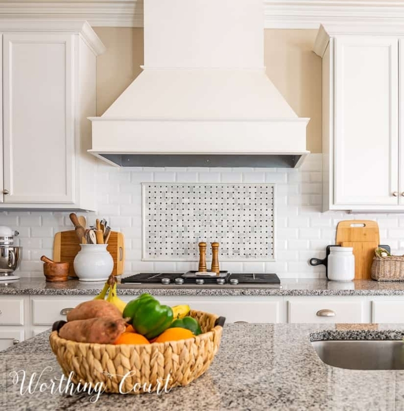 Tapered Range Hood and Mosaic Inlay Backsplash in a Bright Kitchen