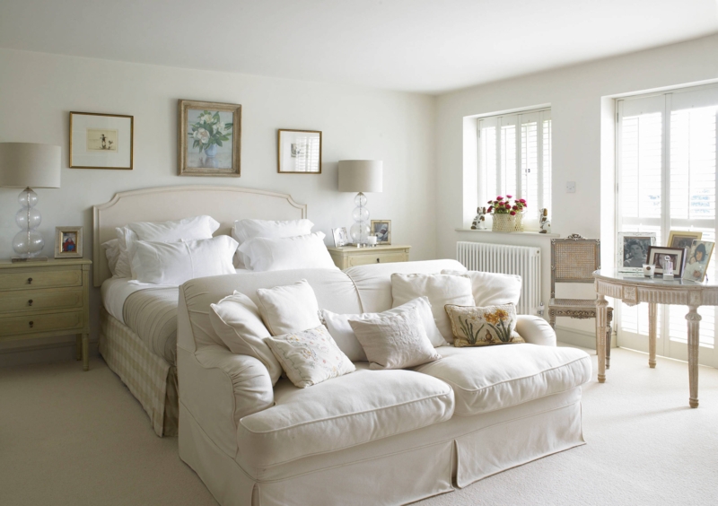 Traditional Bed with Skirted Sofa at Foot and Shuttered Windows