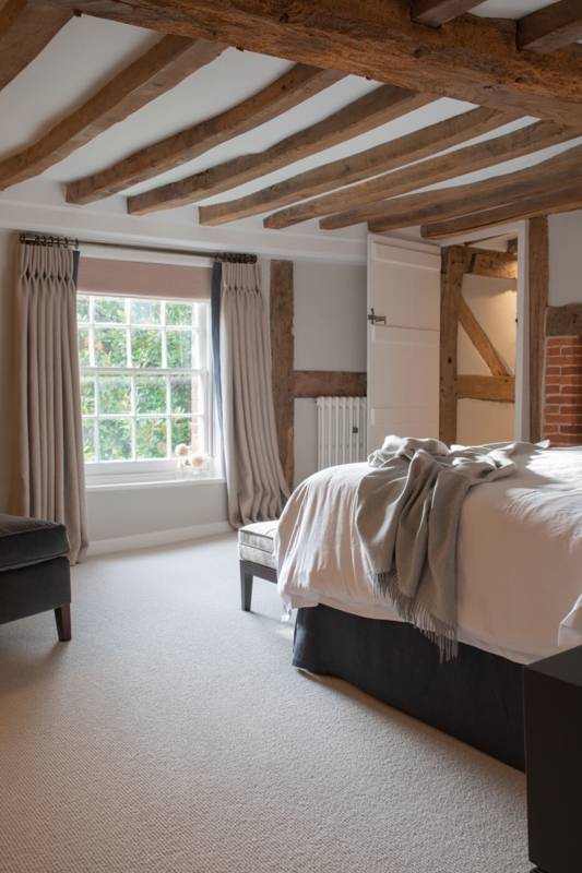 Tranquil Country Bedroom with Rustic Beams and Textured Carpet