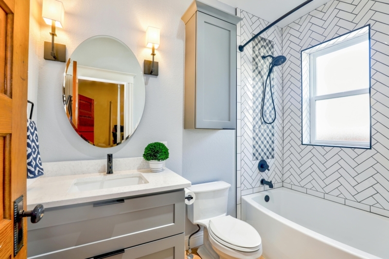 Transitional Bathroom: Gray Vanity with Herringbone Tile Surround