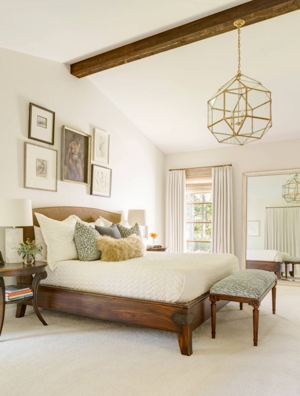 Transitional Bedroom with Geometric Gold Pendant and Dark Wood Beam