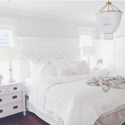 Tufted Bed with Beaded Chandelier and Wainscoting Paneling