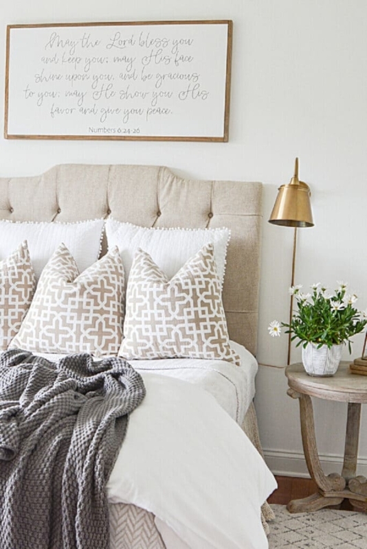 Tufted Headboard Bed with Brass Swing Arm Lamp and Geometric Pillows