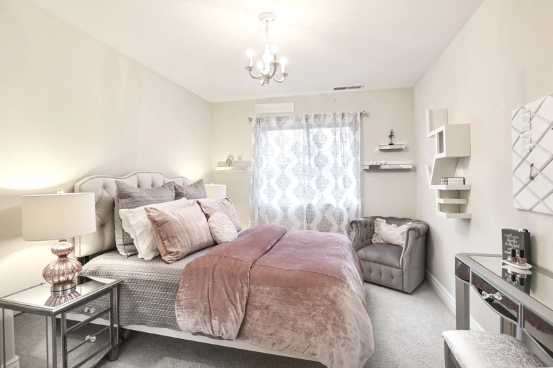 Tufted Headboard Bed with Mauve Velvet Comforter and Gray Chair