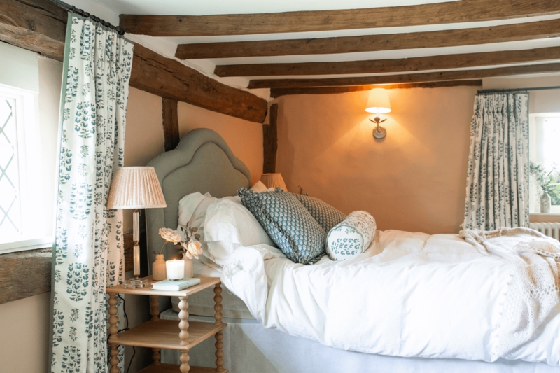 Upholstered Arched Headboard Bed in Country Bedroom with Exposed Beams