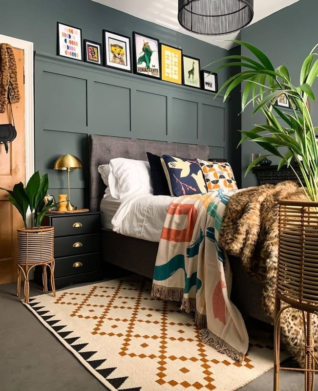 Upholstered Bed against Moody Green Paneled Wall with Picture Ledge