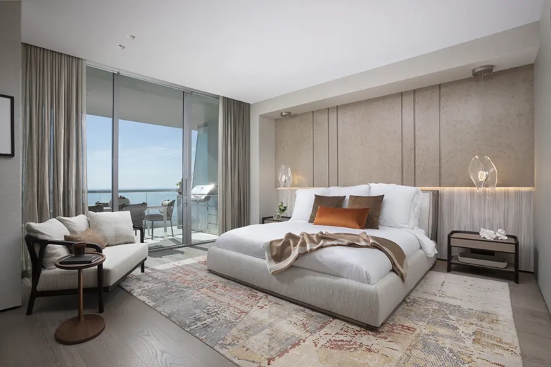 Upholstered Bed Paired with Textured Wall Paneling and Ocean View