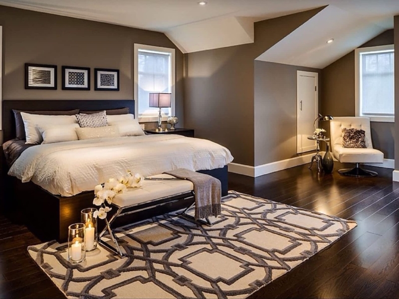 Upholstered Bed with Bold Geometric Area Rug and Dark Brown Walls