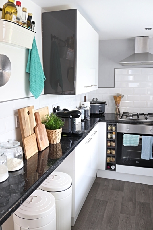 Vertical Spice Rack with Glossy White Cabinets and Black Countertop