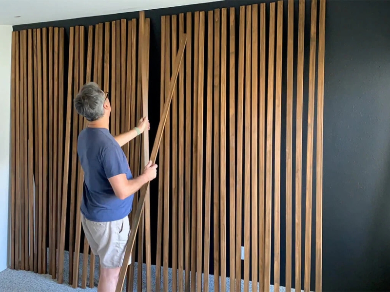 Vertical Wood Slat Accent Wall Installation on Black Background