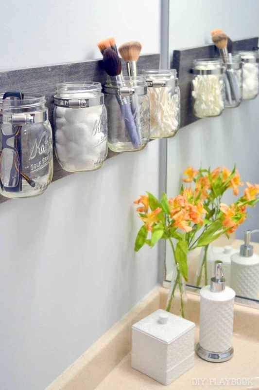 Wall Mounted Organizer using hose clamp mounts on wood. SEO: DIY mason jar bathroom storage.