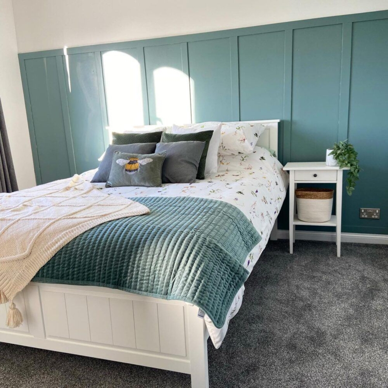 White Bed Frame with Floral Bedding and Board and Batten Wall