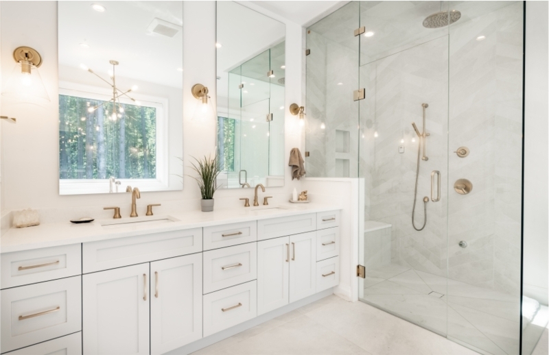 White Double Vanity with Gold Hardware & Chevron Shower Tile