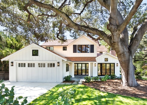 White Farmhouse Exterior with Mature Oak Tree Landscaping