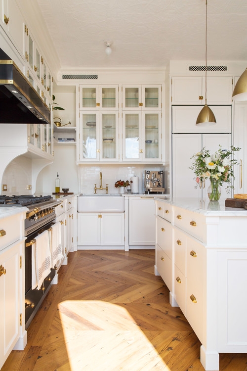White Kitchen with Chevron Wood Flooring and Glass-Front Cabinets