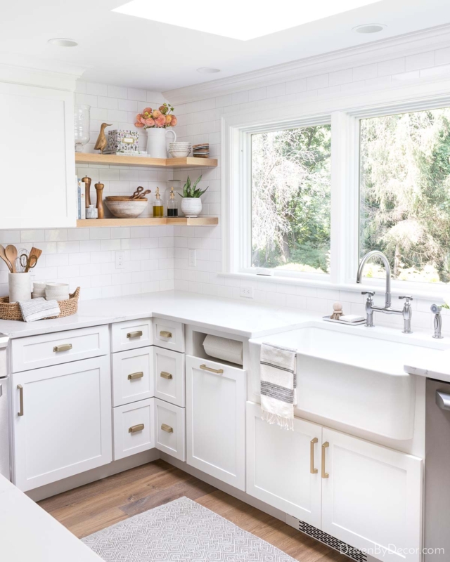 White Kitchen with Corner Floating Shelves and Bridge Faucet