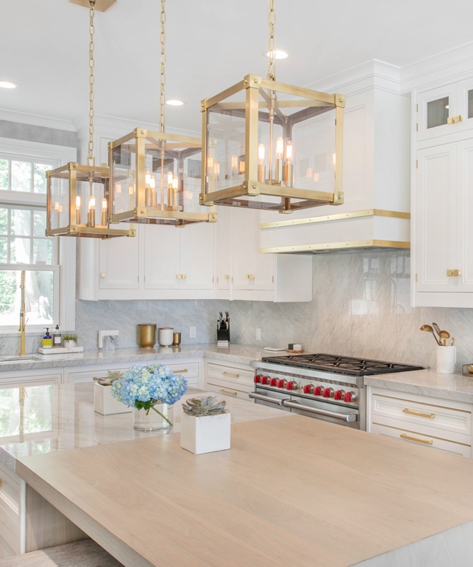 White Kitchen with Three Brass Lantern Pendants and Professional Range