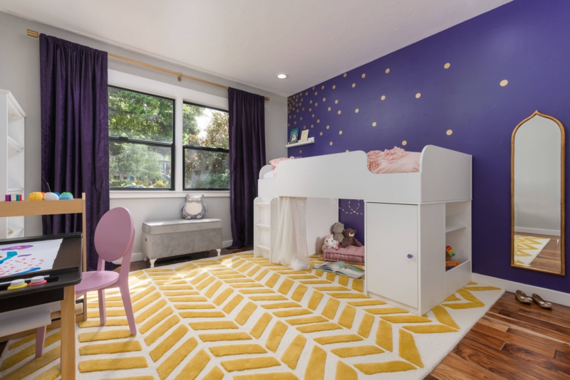 White Loft Bed in Kids Bedroom with Purple Accent Wall & Rug