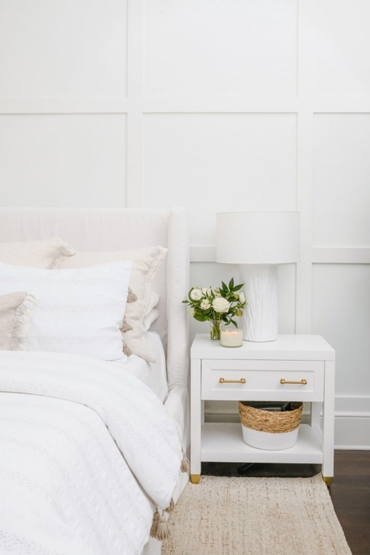 White Nightstand with Gold Accents against Grid Wall Paneling