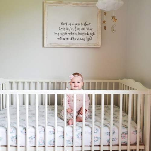 White Scalloped Rail Crib with Floral Bedding in Serene Nursery
