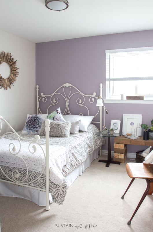 White Scrolled Metal Bed Frame against Mauve Accent Wall