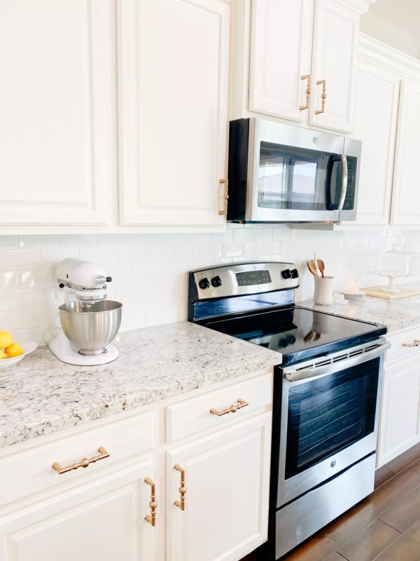 White Shaker Cabinets with Gold Pulls and Speckled Granite Countertops