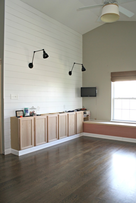 White Shiplap Wall with Swing-Arm Sconces and Built-In Cabinets