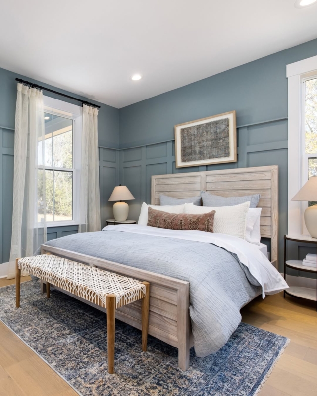 Whitewashed Paneled Bed Against Blue Board and Batten