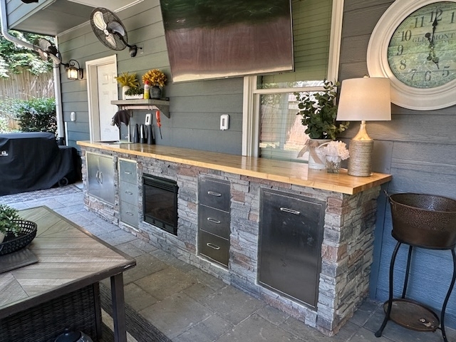 Wood Countertop Patio Bar with Stacked Stone Cladding & Mounted TV