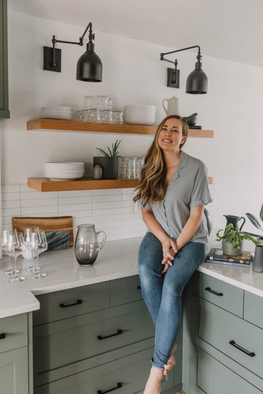 Wood Floating Shelves over Sage Green Cabinets with Black Sconces