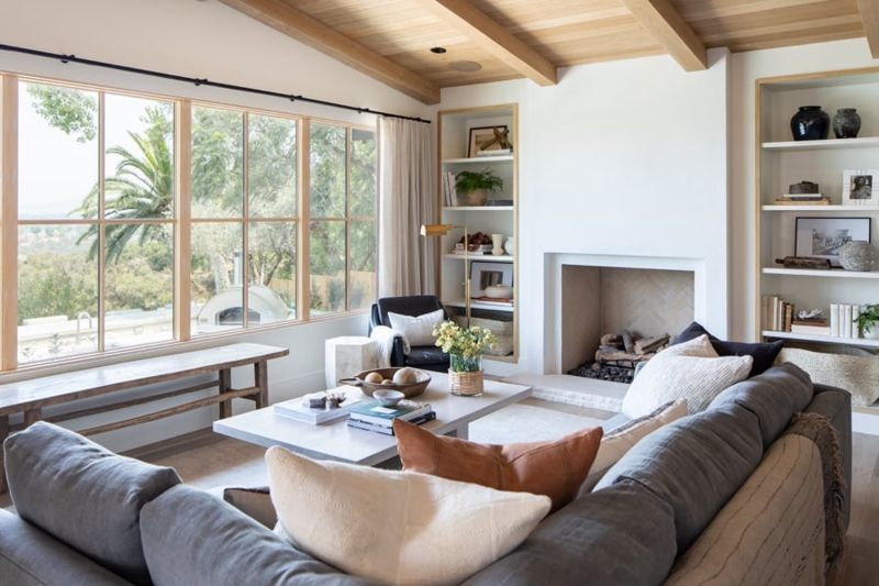 Wood-Framed Living Room Windows with Wood Lined Shelves and Beams