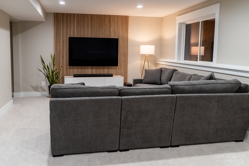 Wood Slat Accent Wall TV Setup in Minimalist Charcoal Basement