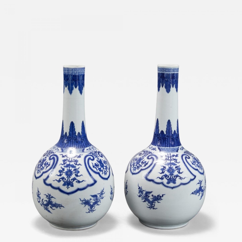 Matching Pair of tall neck ceramic bottle vases with scrolling motifs.