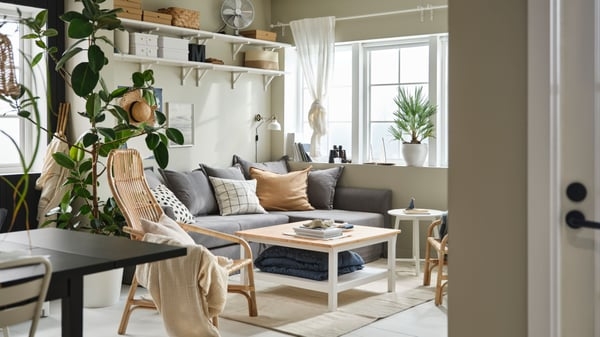 Scandinavian Living Room with Sectional, Rattan Chair & Wall Shelving