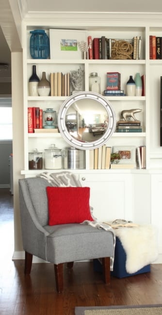 Wall Mirror with Porthole Frame Mounted on Bookcase for Coastal Decor
