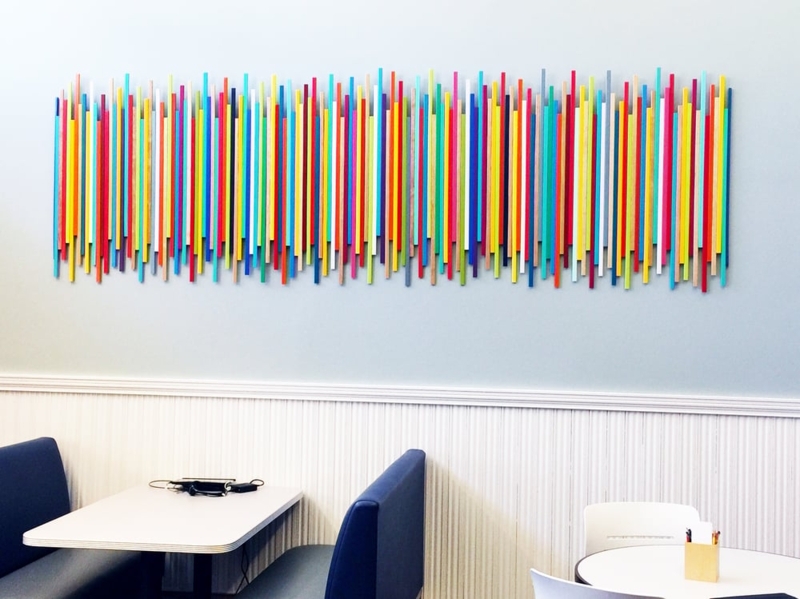 Wood Wall Sculpture: Multi-color sticks, three-dimensional, linear art.
