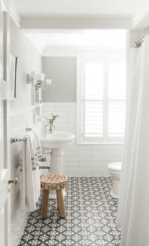 Black and White Patterned Bathroom Floor with Subway Tile Wainscoting